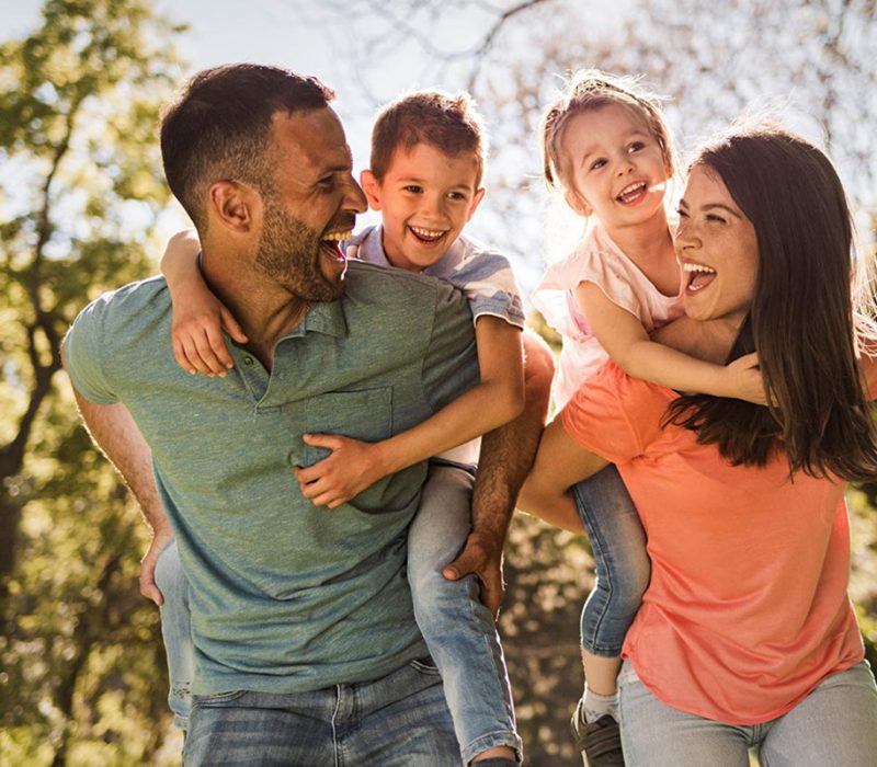 Dad and mom giving kids piggybacks