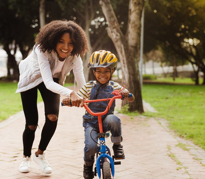 Mom teaching son how to ride bike