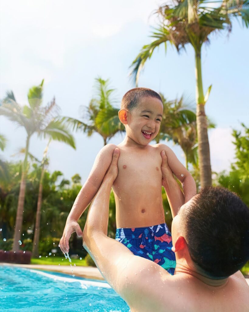 Father and son playing in swimming pool