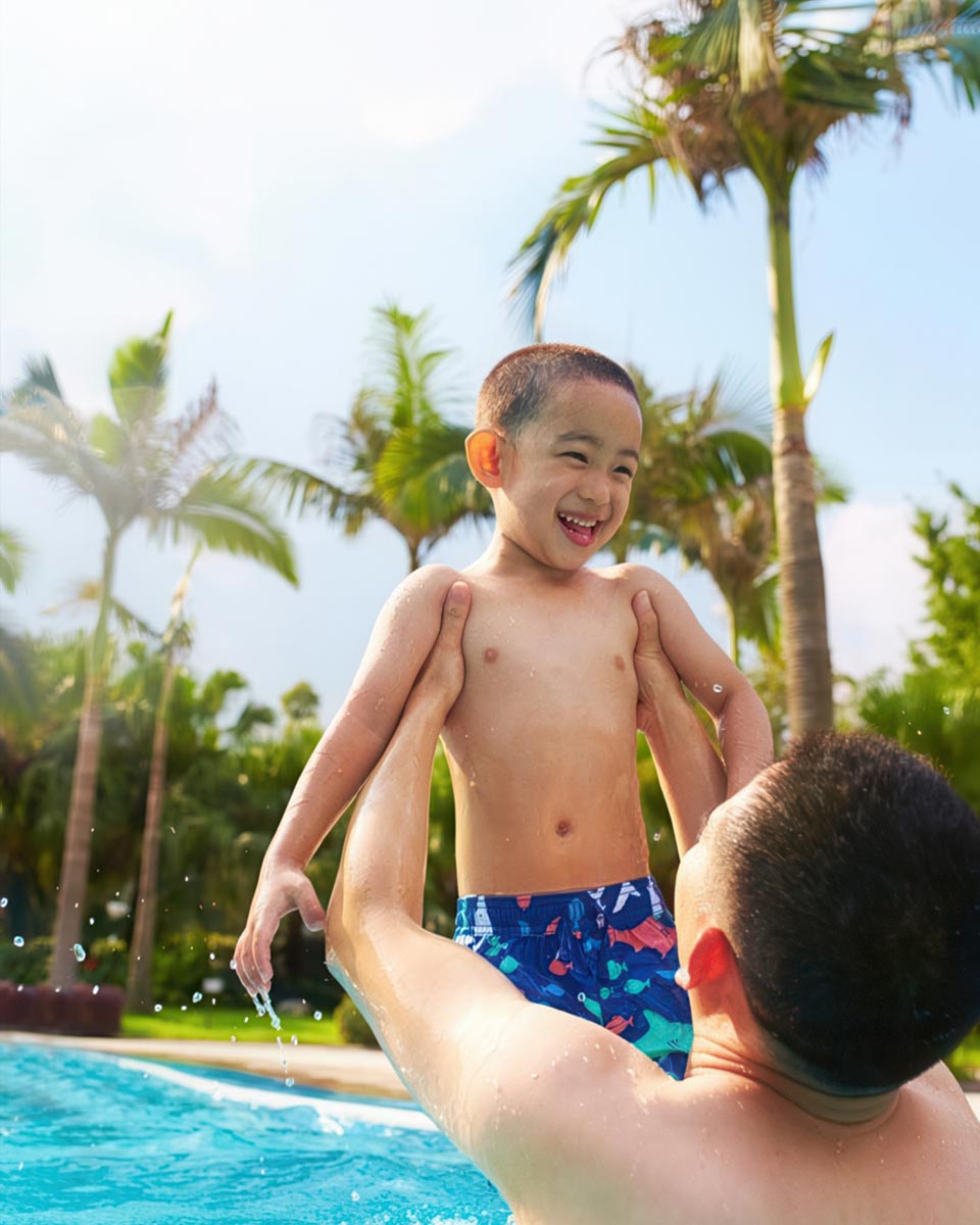 Father and son playing in swimming pool