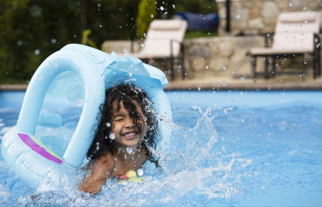 girl playing in pool with raft