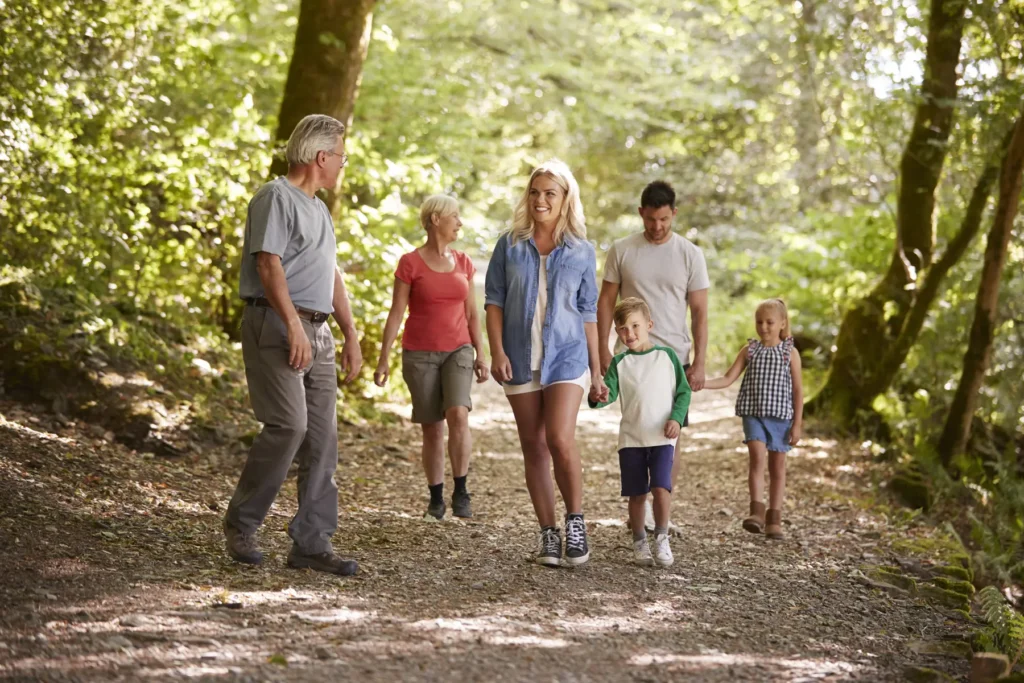 Multi Generation Family Enjoying Walk Along Woodland Path Together