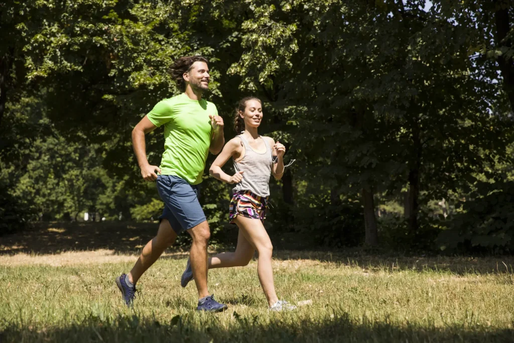 Young couple running in nature on a sunny summer day